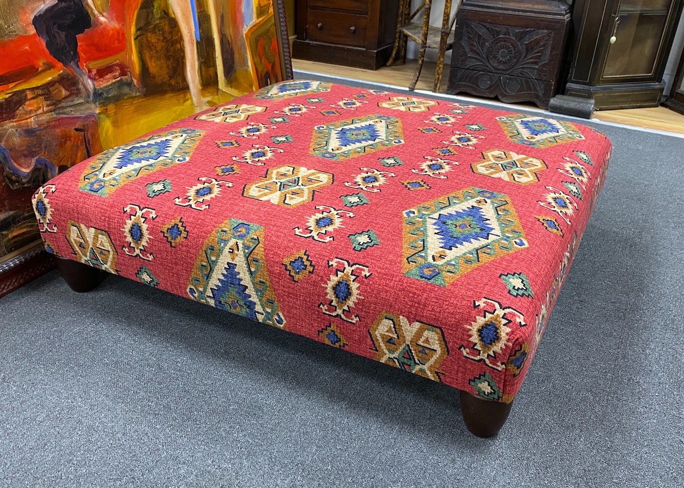 A large square contemporary footstool upholstered in red ground Kilim style fabric, width 102cm, height 27cm